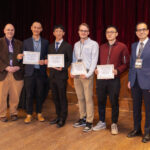 A group of four students pose as Poster Award winners pose between Mark Bock and Mujdat Cetin