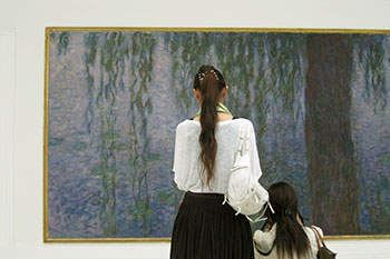 Two women in front of a French painting