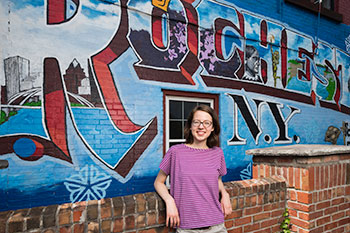 A student in front of a mural