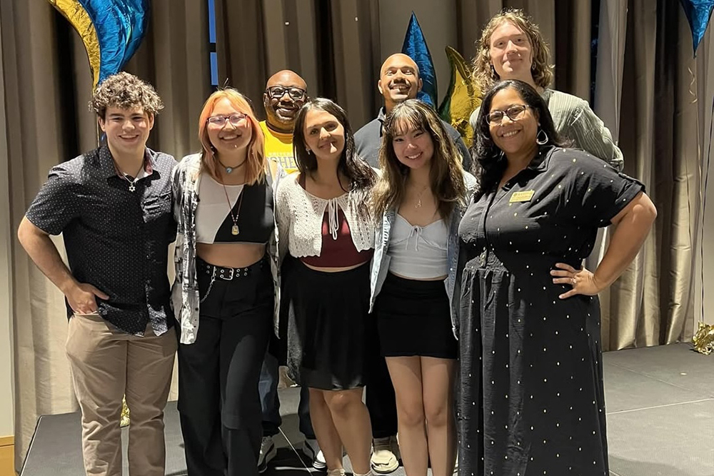 A diverse group of people standing together and smiling at the camera.