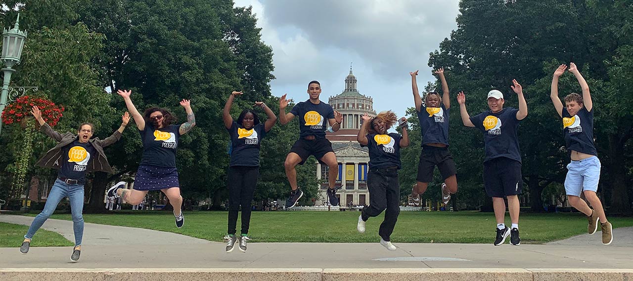 Peer advisors on Eastman Quad jumping in the air.