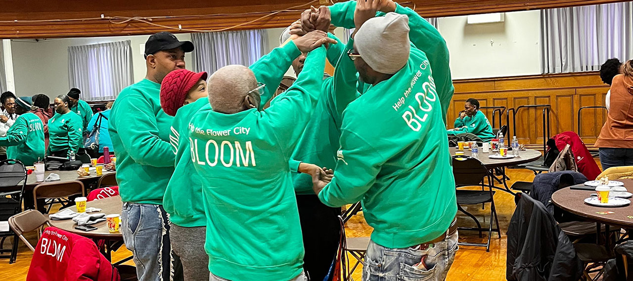 A group of student volunteers wearing green sweatshirts as part of the Help the Flower City Bloom event.