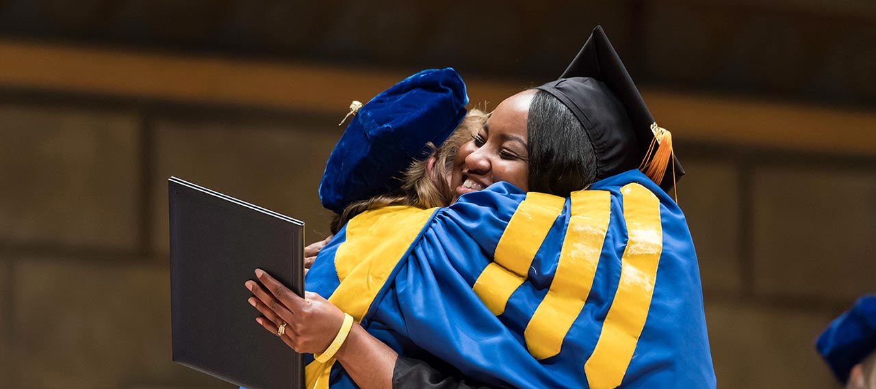 A woman receiving her degree at commencement.