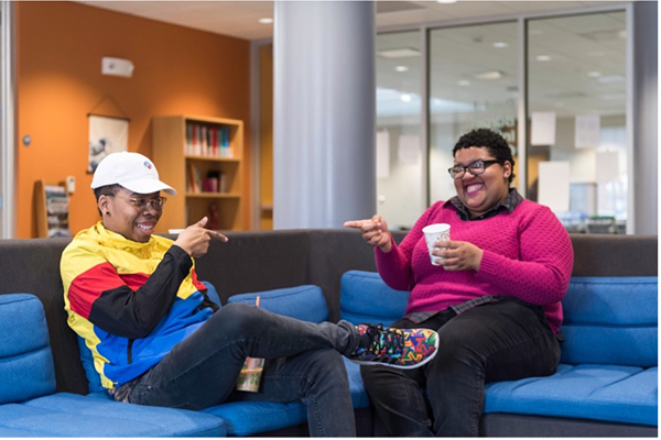 Two people sitting on a sofa in the Language Center.