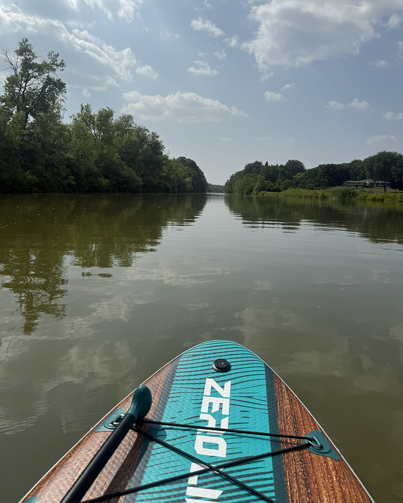 The front half of a paddle board on water.