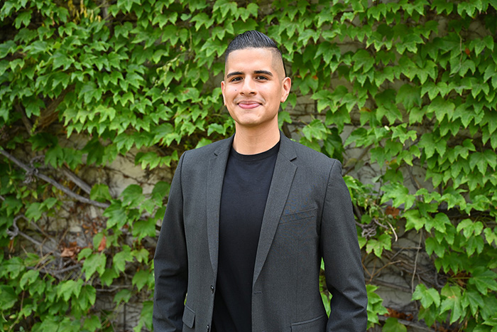 Director Baique posing in front of some foliage.