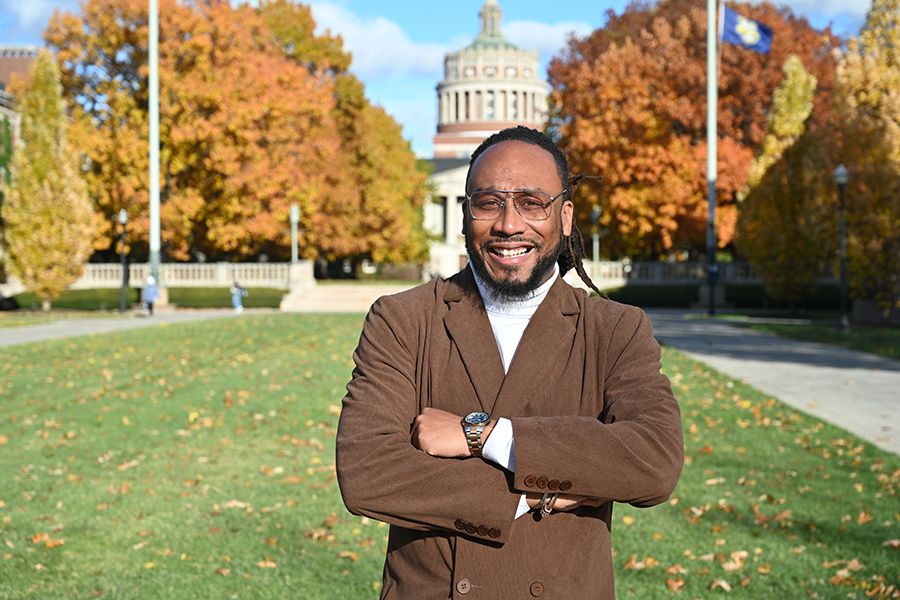 A person standing outside on a sunny day smiling at the camera.