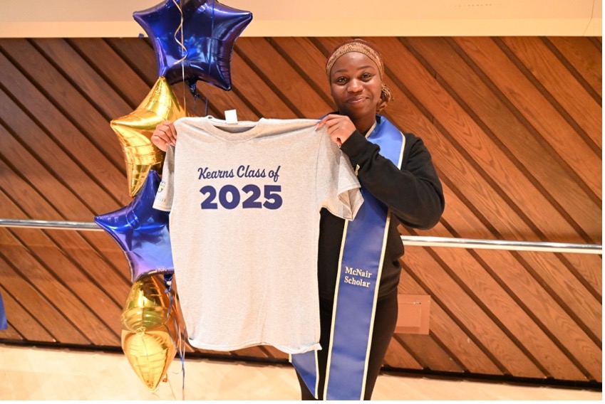 A person holding up a t-shirt.