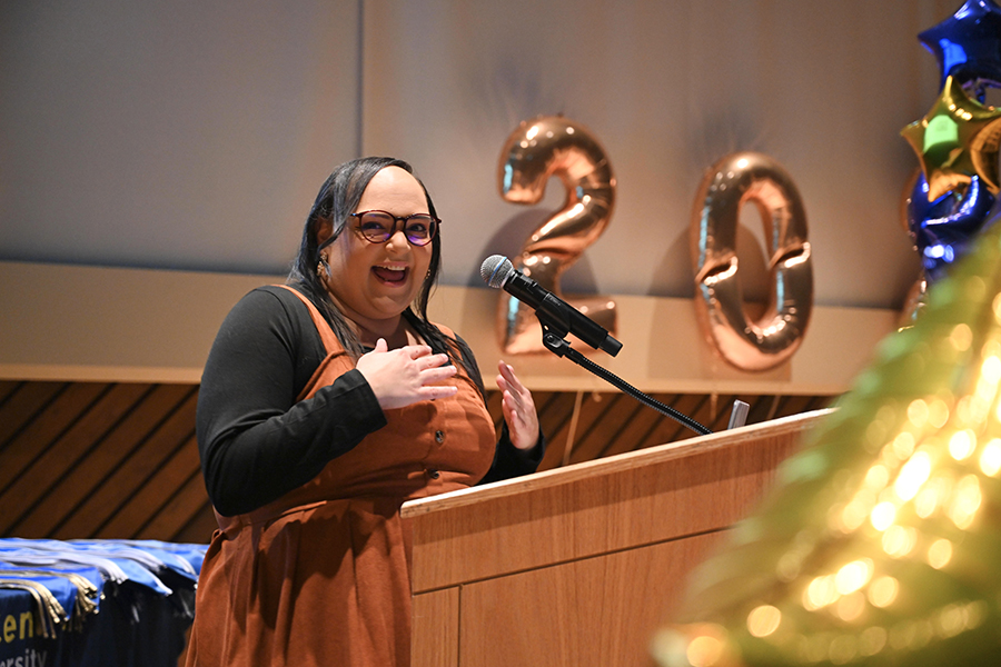 Melissa standing behind a podium with an animated face.