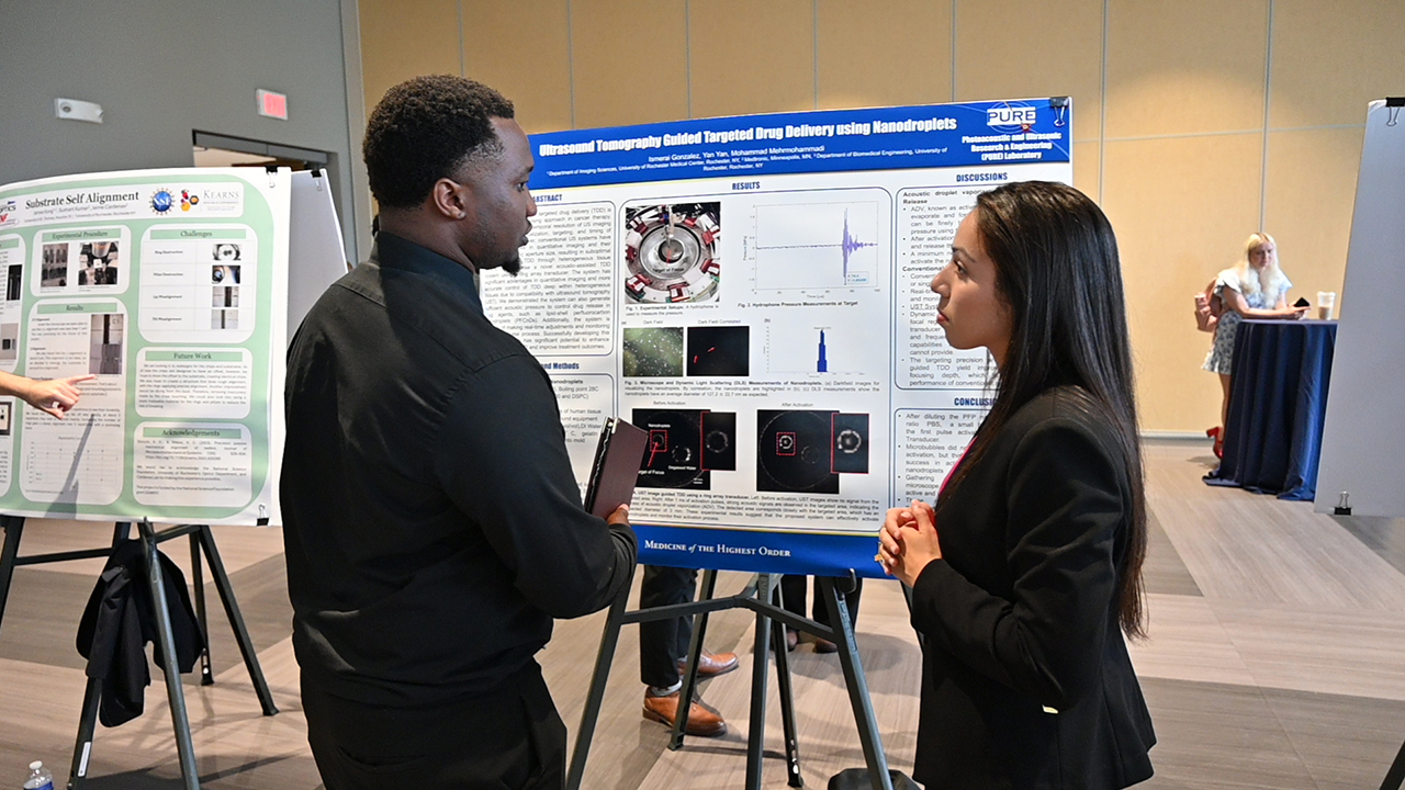 A student showing their work at a poster presentation.
