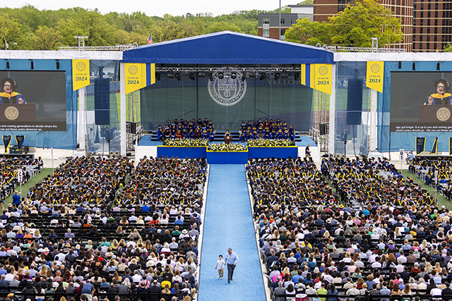 An aerial view of the stage, crowd, and walkway for commencement.