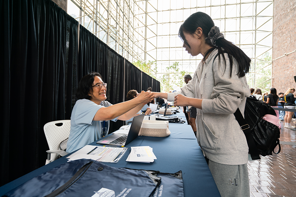A faculty member assists a student at Welcome Week check-in during Fall 2026 Welcome Week.