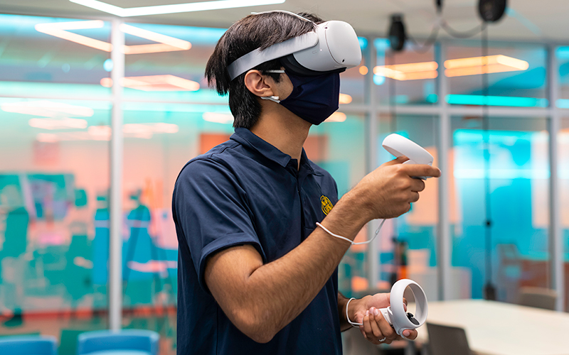 Photo of former Orientation Leader Waleed Nadeem using a virtual reality headset during a past Fall Welcome Week event