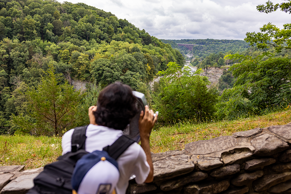 A student looks through a tower viewer in Letchworth State Park during the 2025 FOOT program