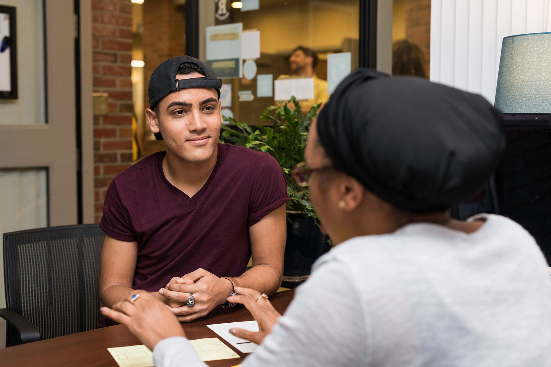 A student faces a staff member in the foreground