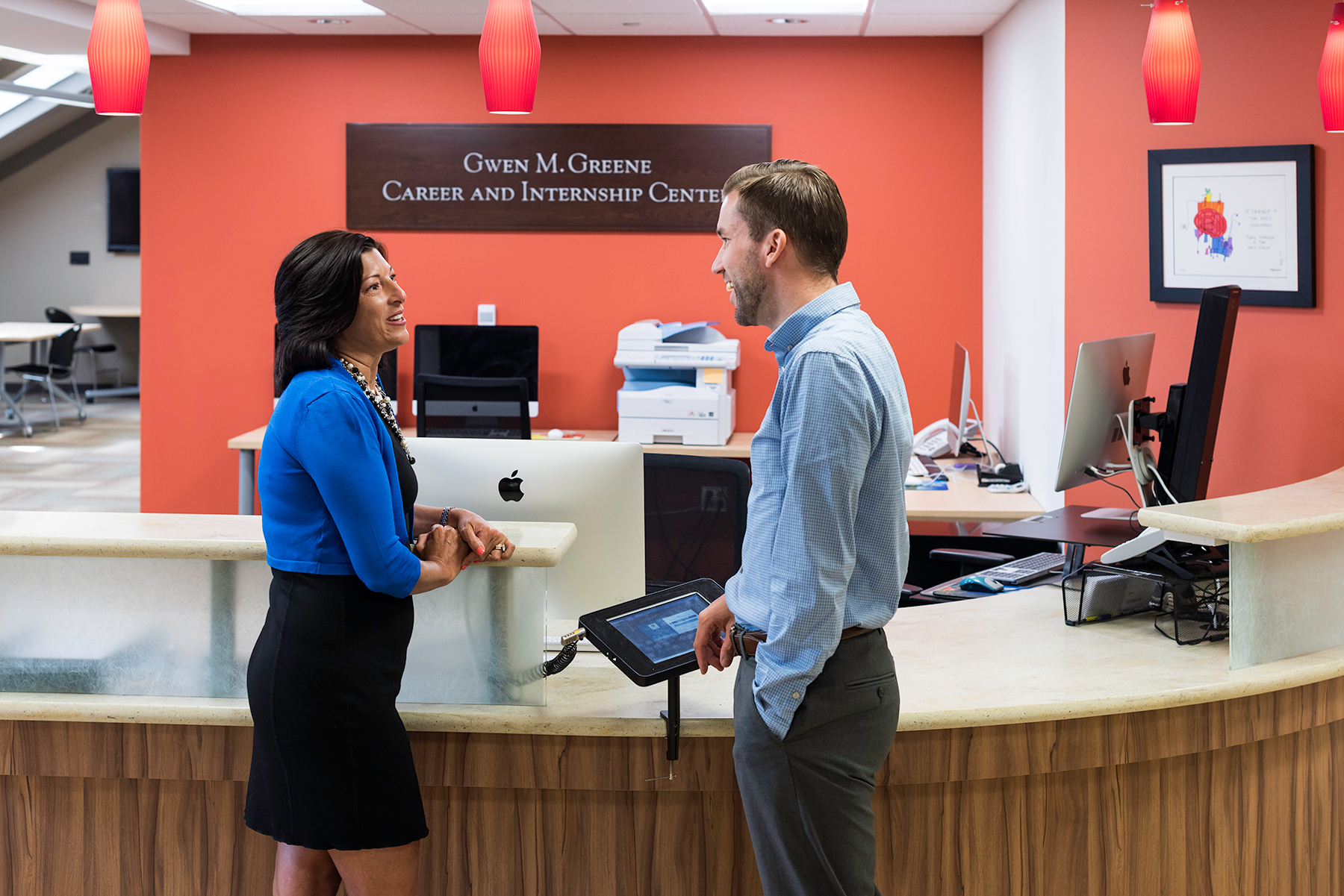 Two staff members talking at the front desk of the Greene Center