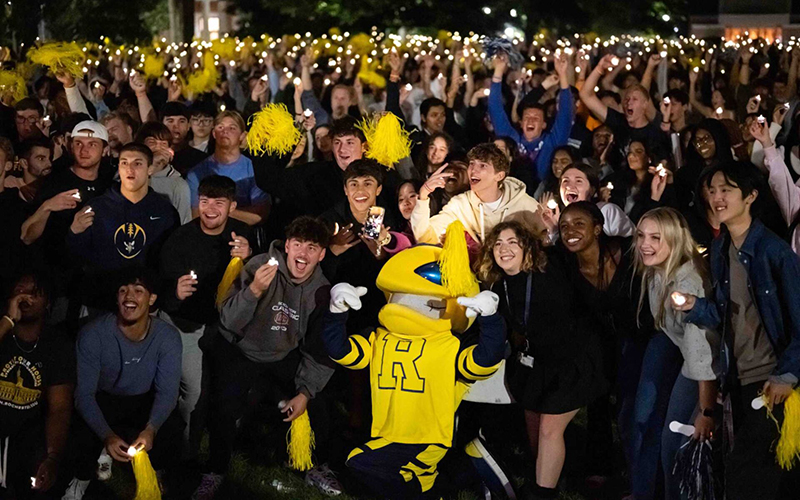 Photo of students posing with Rocky at Candlelight Ceremony