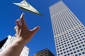 Person Reaching for Paper Airplane Made of Money