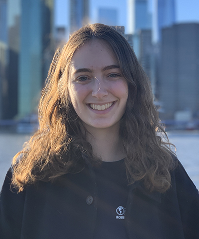 Headshot of Lia Polster with the NYC skyline in the background.