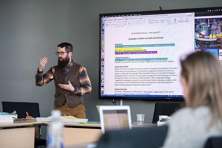 A professor teaching a class using technology tools.
