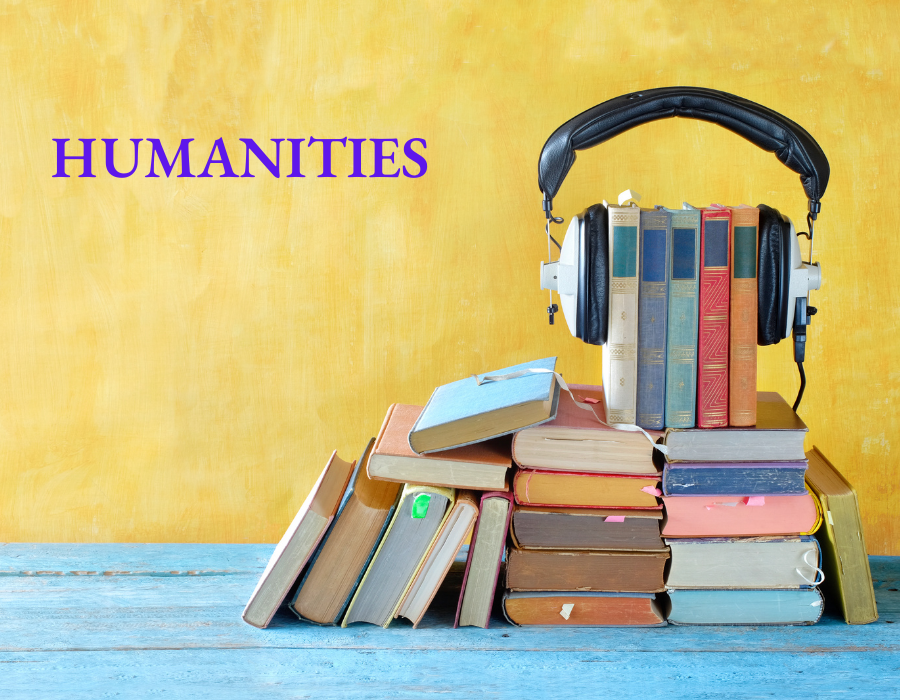 A pyramid of books with headphones on the top of them.