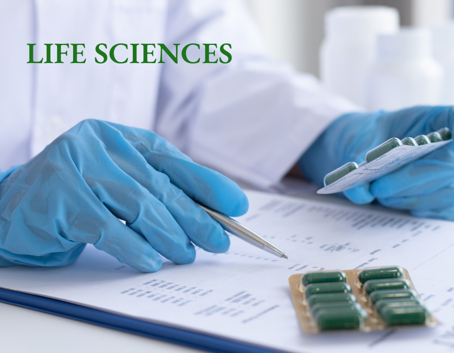 Gloved hands checking a list while holding packets of pills.
