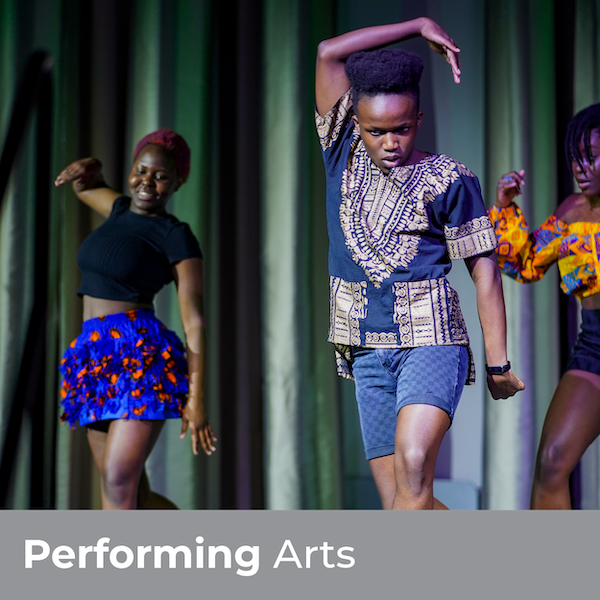 Performing Arts - Three students dancing on a stage in traditional garb