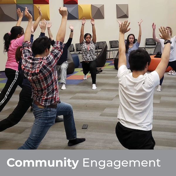 Community Engagement - Students in a circle doing yoga with their arms extended upwards