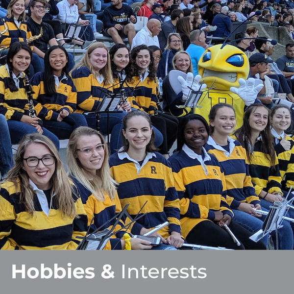 Hobbies & Interests - Pep Band students smiling in the stands of Fauver Stadium