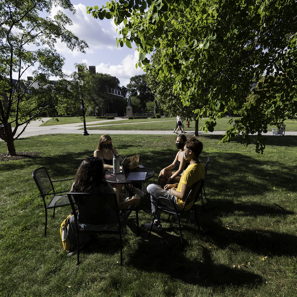 Group of students working at a table outside