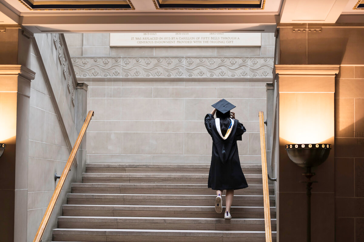 A University of Rochester graduate walking up the stairs