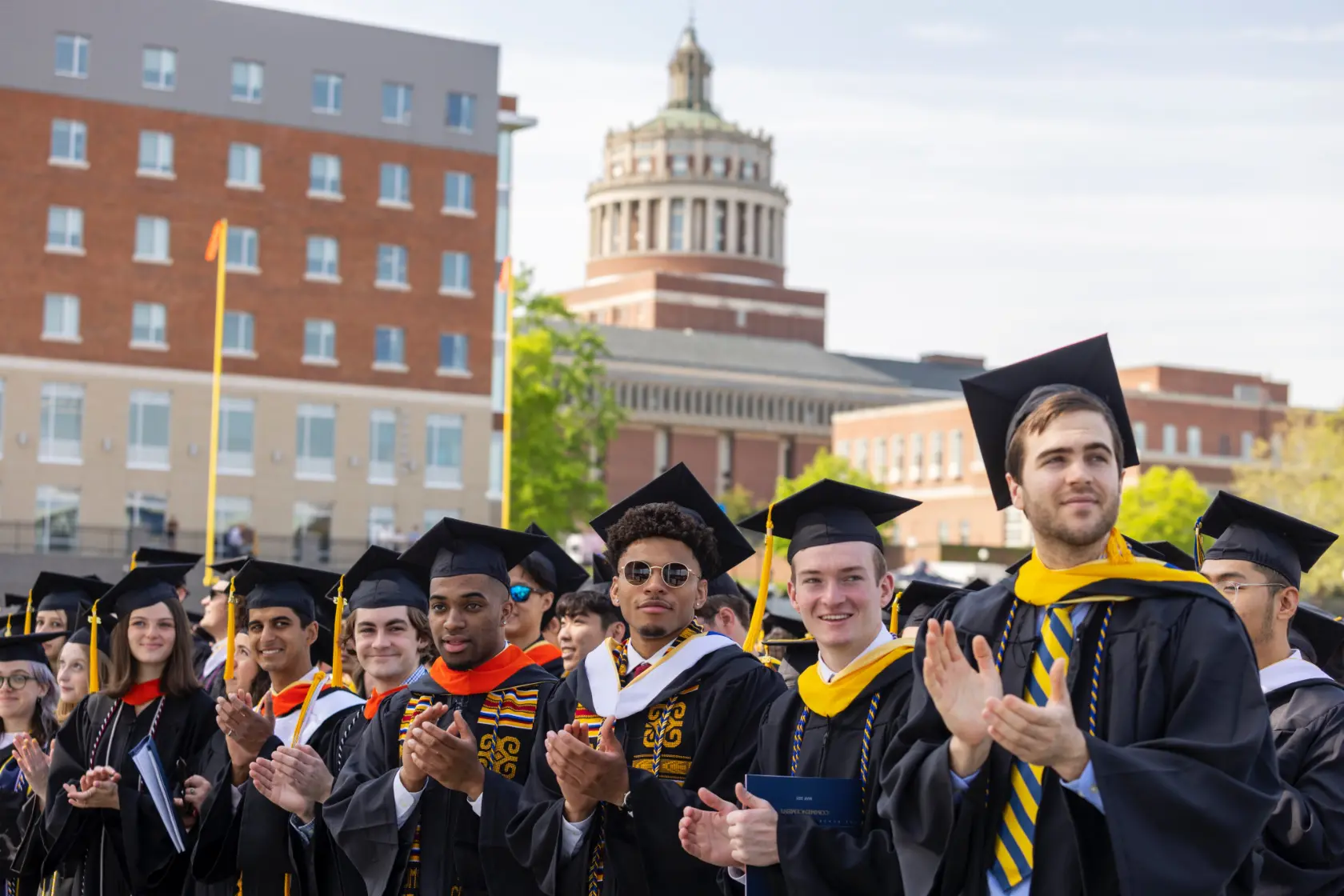 Graduates at the University of Rochester Commencement Weekend applaud during the graduation ceremony, celebrating their achievements.