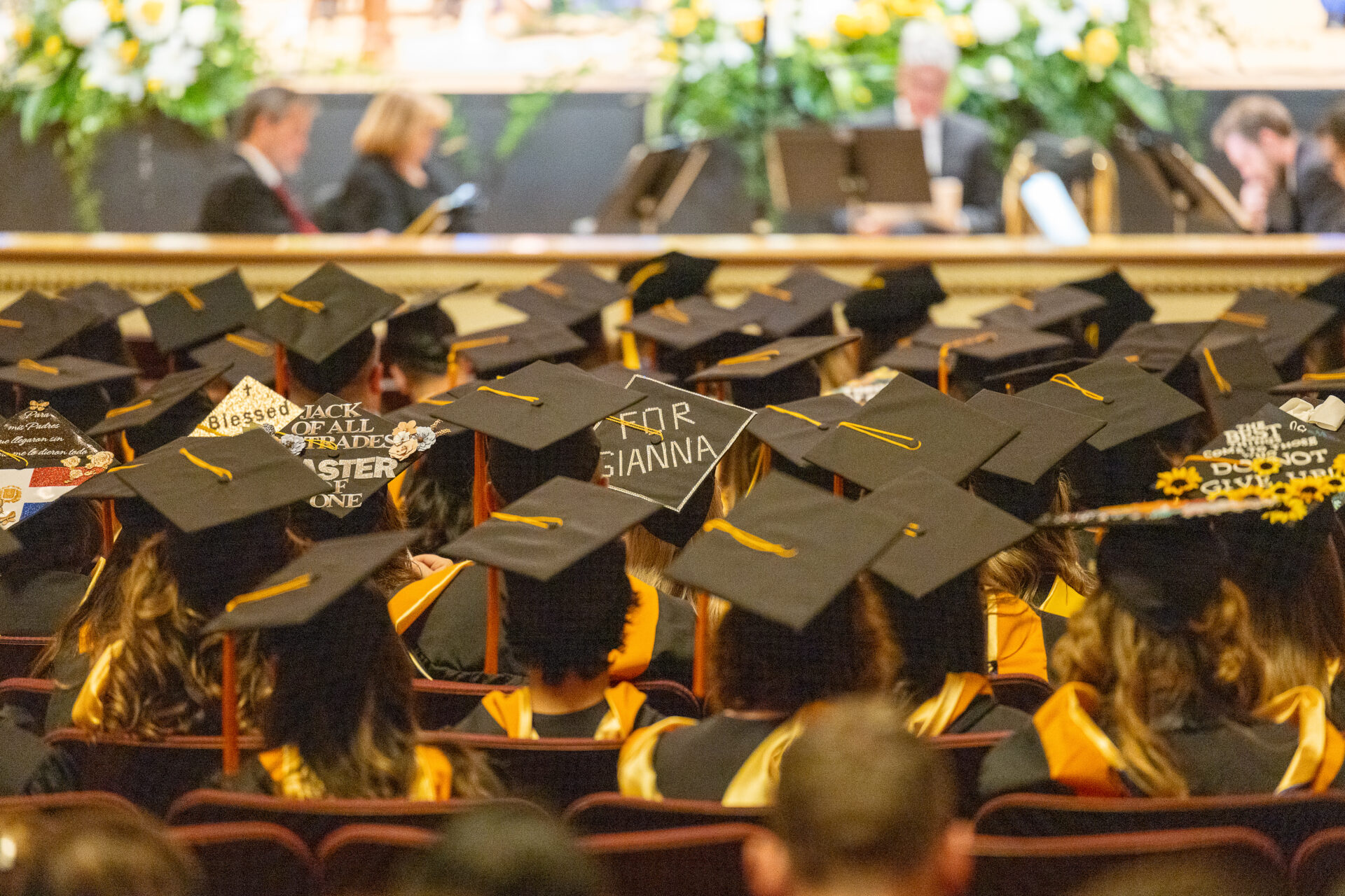 A view of the crowd shows the backs of students' graduation caps.