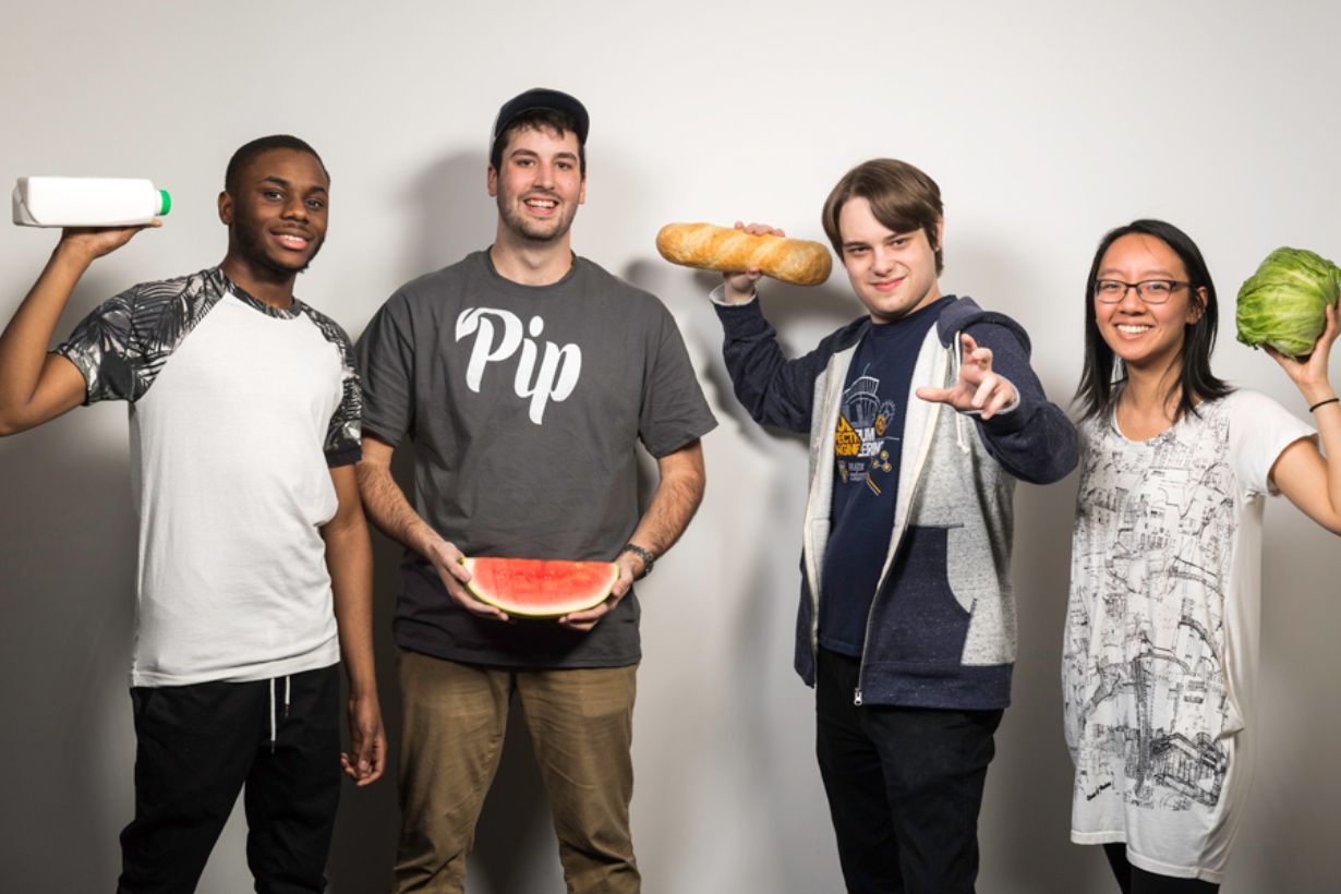 Four students each holding an item from a refrigerator: milk, watermelon, bread, lettuce.