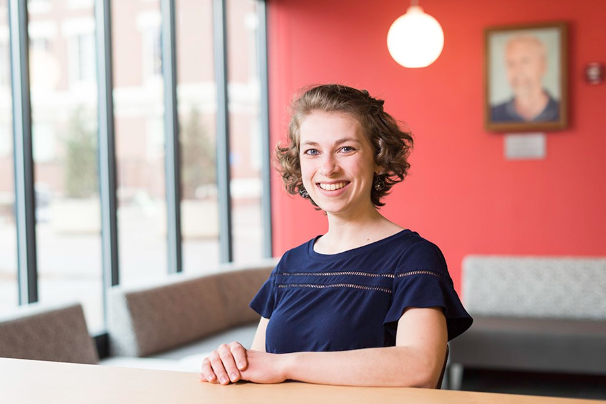 Hannah Dick seated in Meliora Hall.