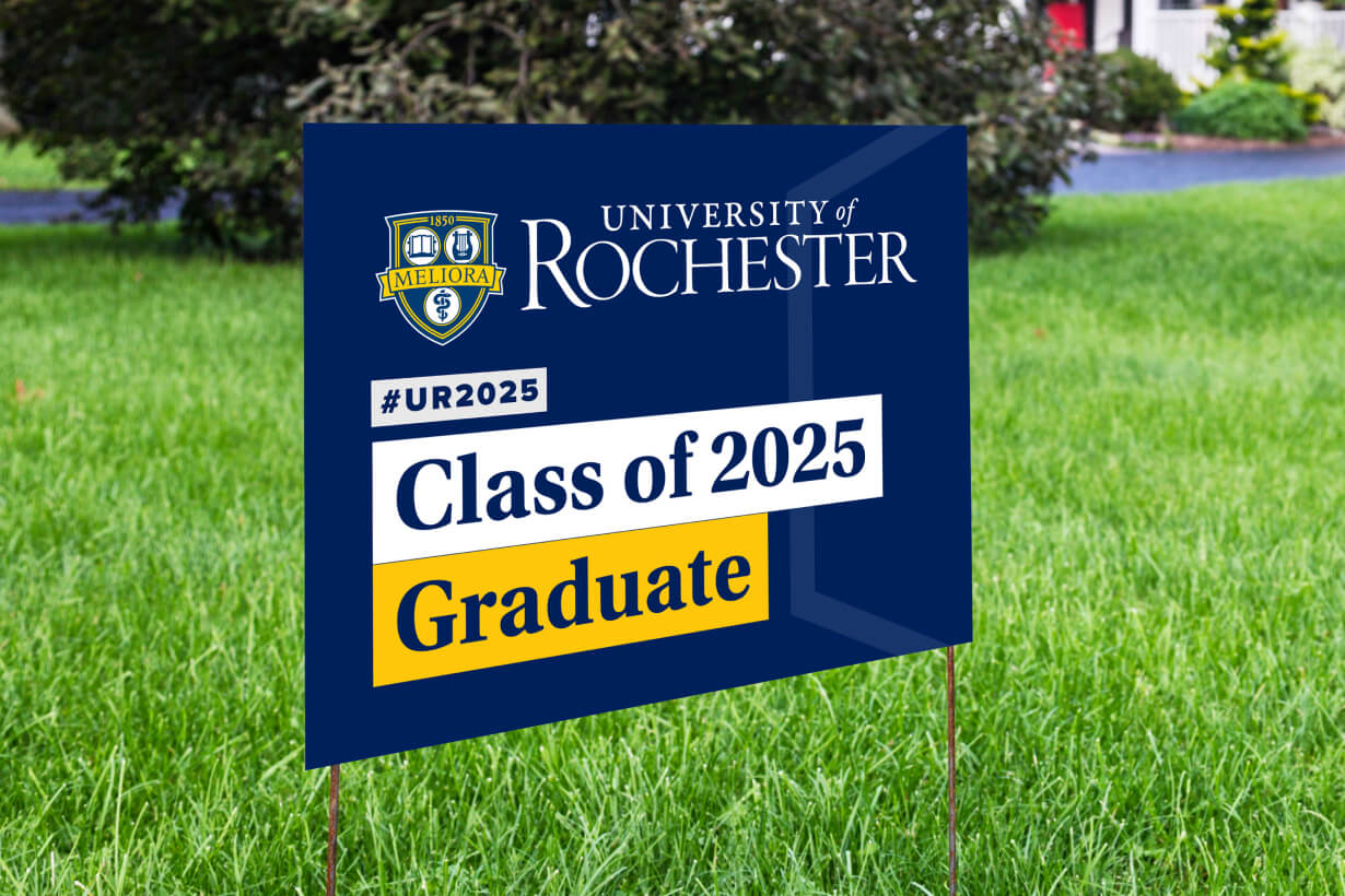 A yard sign celebrating a University of Rochester graduate, featuring the university's logo and graduation year.