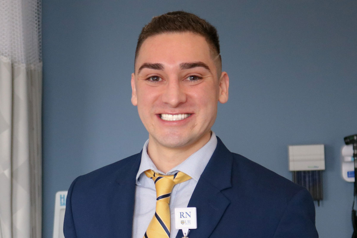 Matt Ramos, a University of Rochester Class of 2025 student, smiles in a suit and tie for the camera.