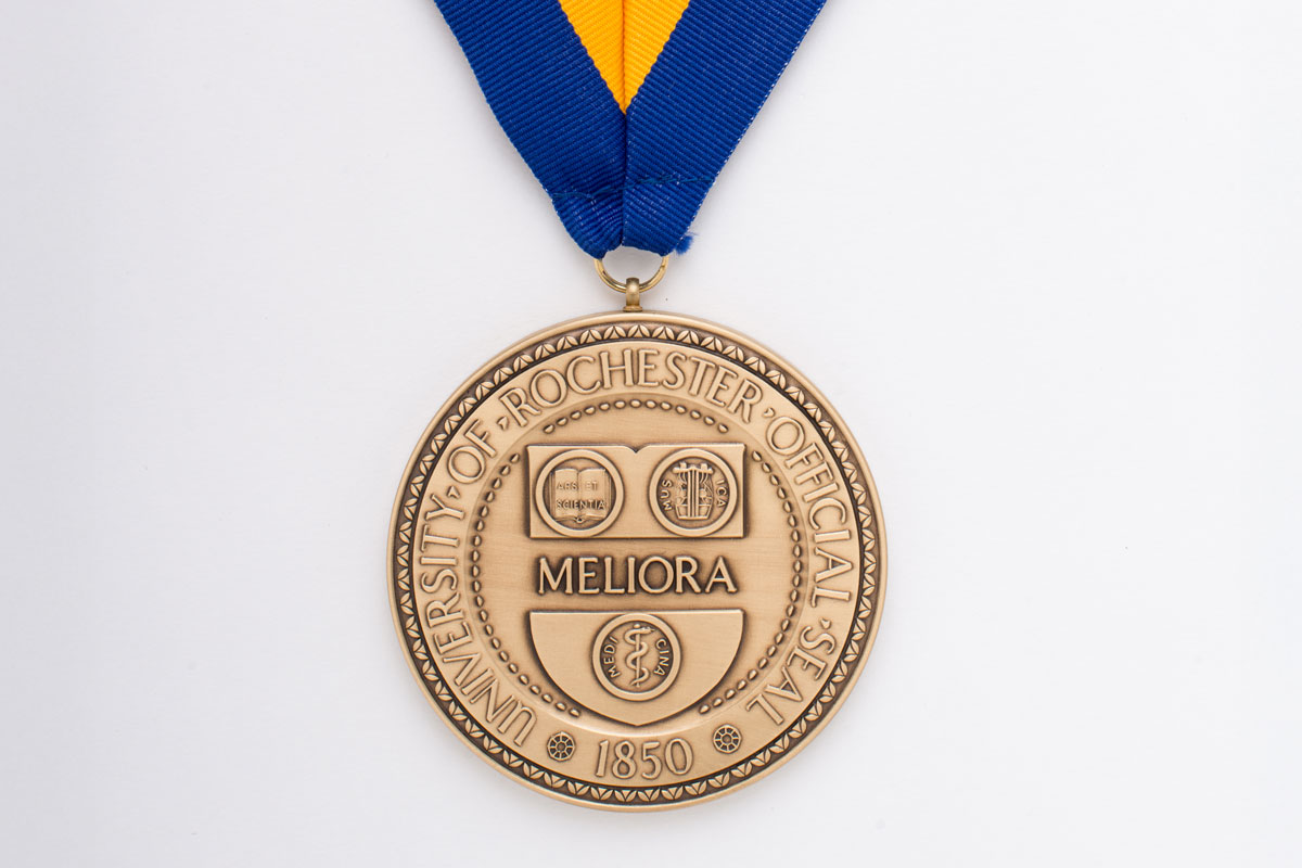 Gold medal with a blue ribbon, representing the University of Rochester 2025 Honorary Degrees, Medals, and Awards.
