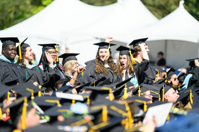 University of Rochester graduates cheer and raise their hands during Commencement Weekend.