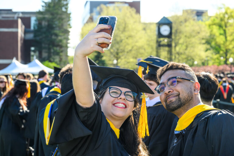 Two University of Rochester graduates take a selfie together during Commencement Weekend.