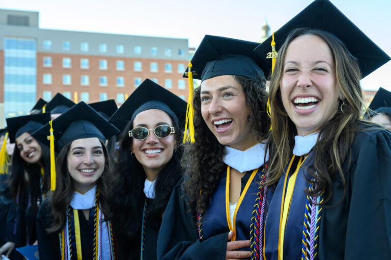 University of Rochester graduates laugh together during Commencement Weekend.