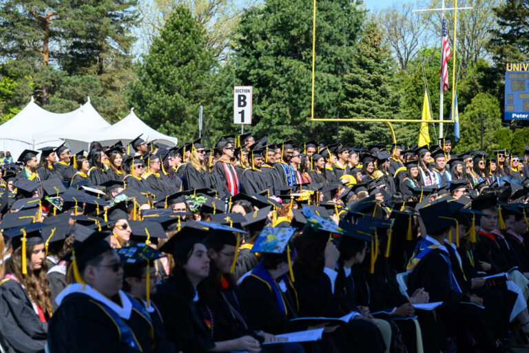 University of Rochester graduates stand and clap during the Commencement Weekend ceremony.