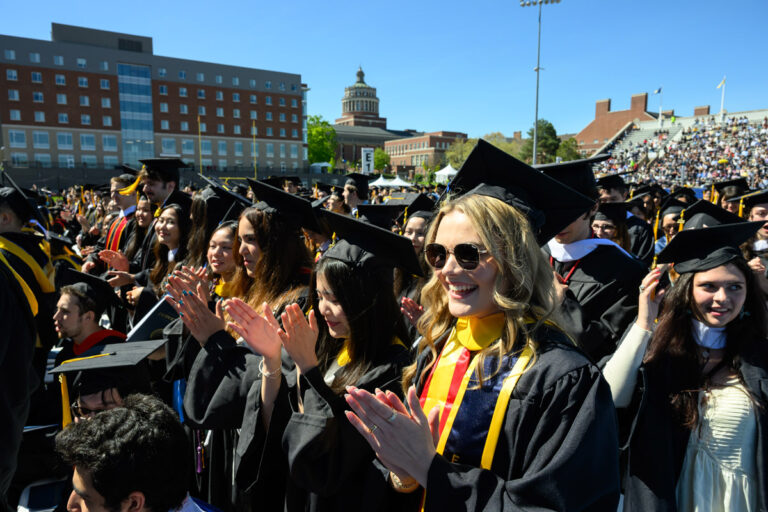 University of Rochester graduates smile and adjust their caps during Commencement Weekend.