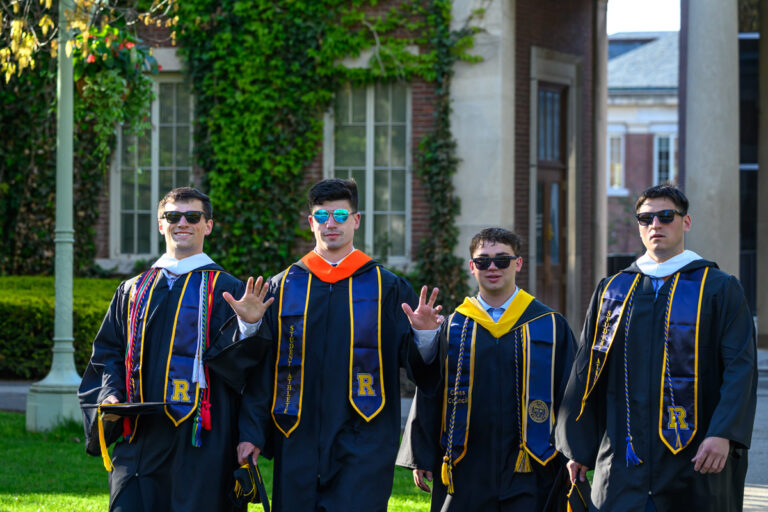 University of Rochester graduates pose together in academic regalia before the Commencement Weekend ceremony.
