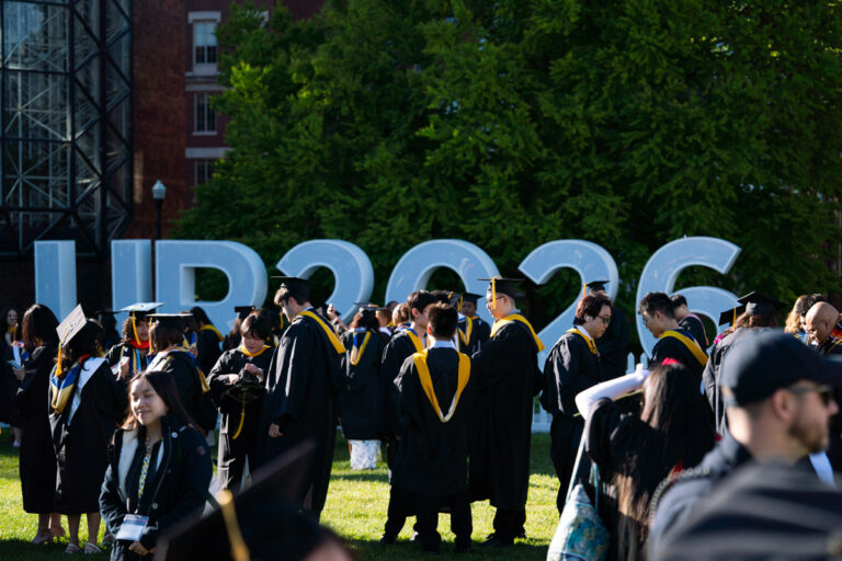 University of Rochester graduates gather near large UR2026 letters during Commencement Weekend.