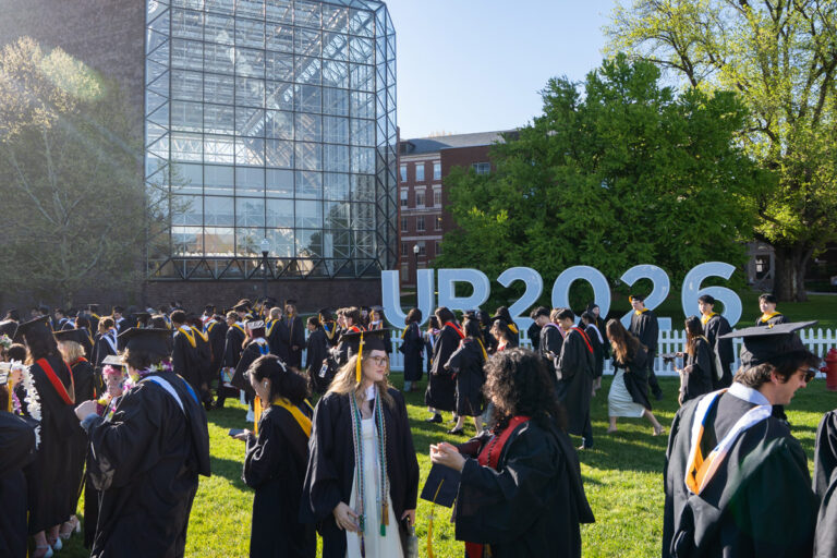 University of Rochester graduates gather near the UR2026 letters outside Wilson Commons during Commencement Weekend.