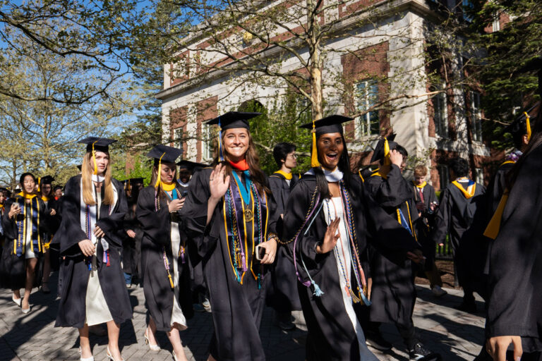 University of Rochester graduates wave while walking in procession during Commencement Weekend.