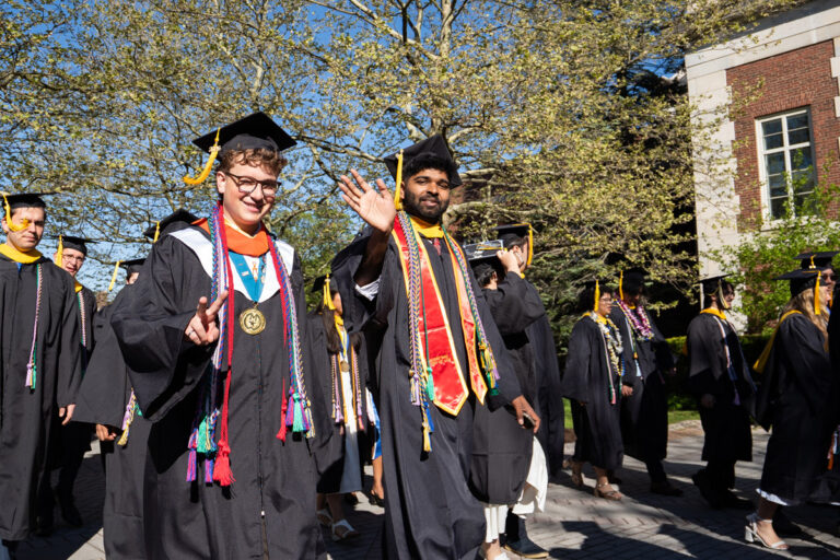 University of Rochester graduates wave while walking in procession during Commencement Weekend.