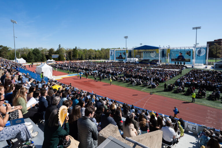 Wide shot of the University of Rochester Commencement Weekend ceremony at Fauver Stadium.