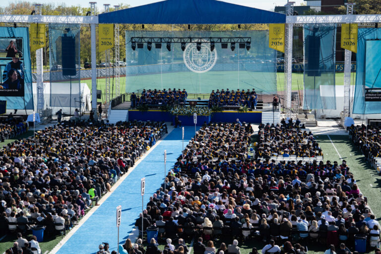 Wide shot of University of Rochester graduates, faculty, and guests facing the stage during the Commencement Weekend ceremony.